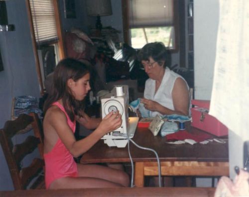 Em helping Anna learn to sew